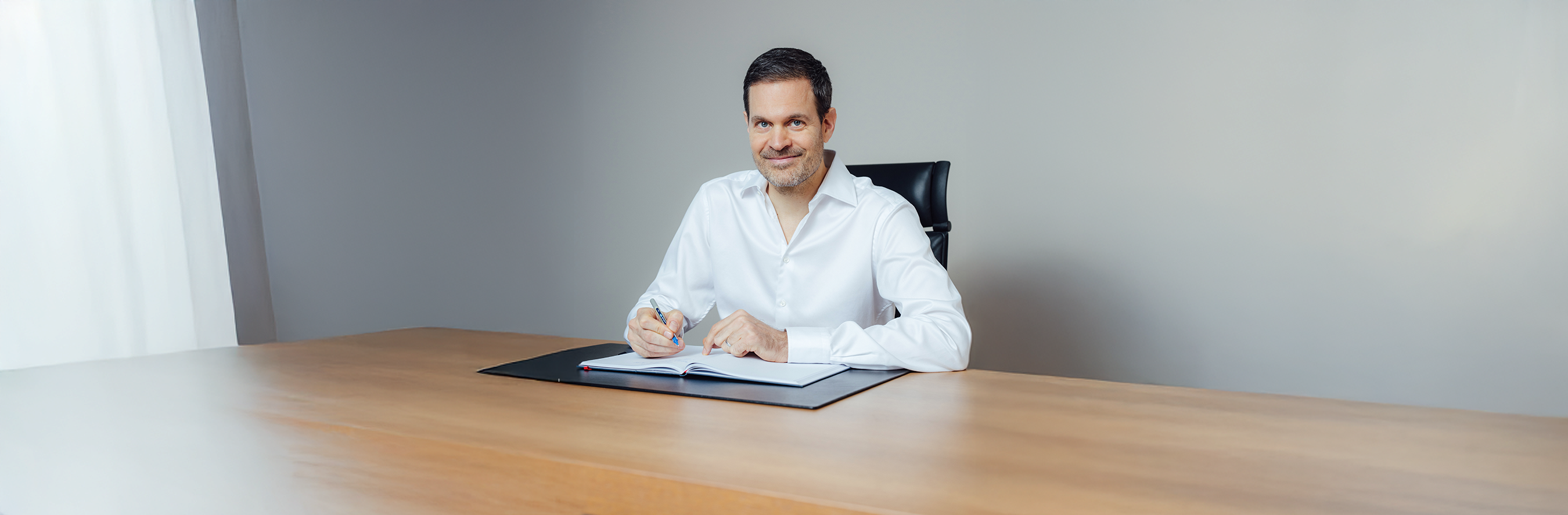 Benjamin Otto sitting at a desk with a book and pen